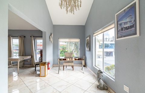 Bright sitting room with tall windows looking out onto the street