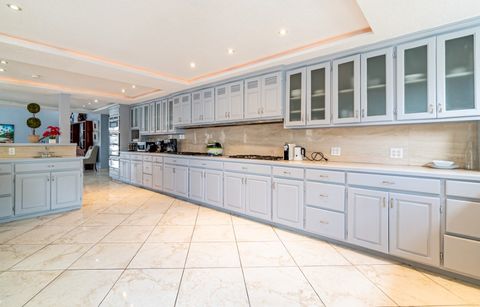 Long galley kitchen with pale cabinets and a run of counter space
