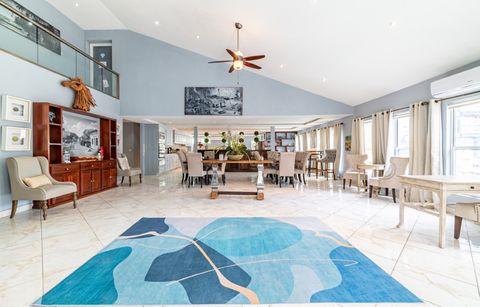 The great room from the far end, with the dining table and a blue island rug