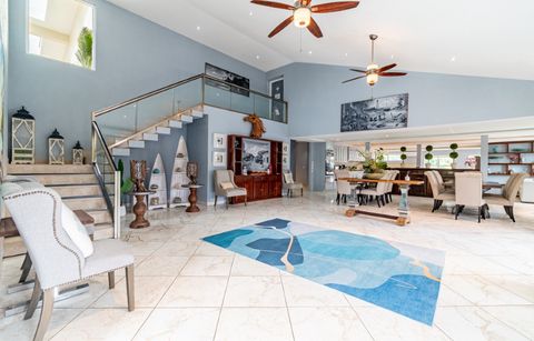 Open-plan great room with a staircase, high ceiling and a dining table beyond