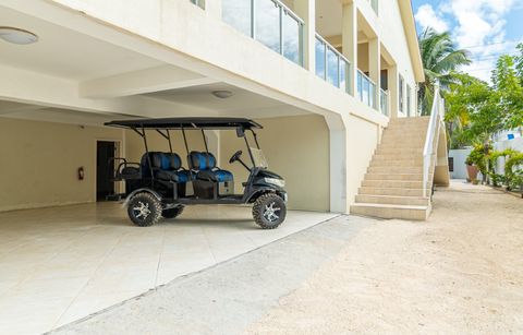 Covered ground-floor parking with a golf cart and the stairs up to the rooms
