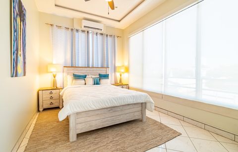 A second bedroom at Sea Horizon, with a light wood bed frame and a large window