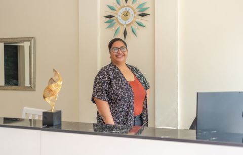 A member of the Sea Horizon team smiling behind the reception desk