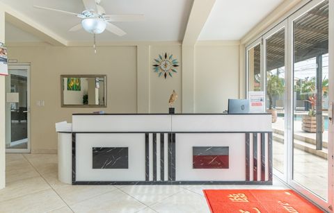 The reception desk with a sunburst wall clock and sliding doors out to the deck