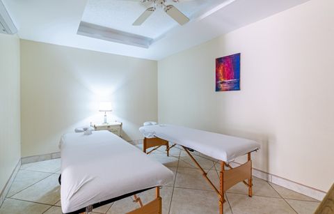Quiet treatment room with two massage tables and folded towels