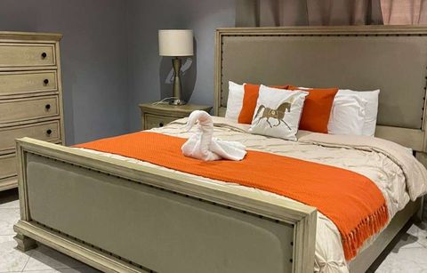 Luxury Suite with a king-size bed, an orange throw and a tall chest of drawers